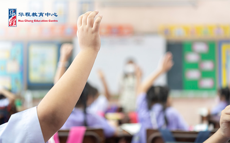 Students raising hands during Chinese holiday programme